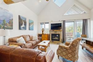Una sala de estar con un sofá y una chimenea. en Saddle Ridge G4, en Big Sky