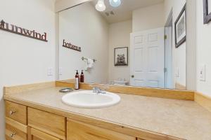 un baño con lavabo y espejo en Saddle Ridge G4, en Big Sky 15 fotos más