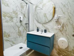 Un baño con un lavabo azul y una ducha. en Barco, en Alicante