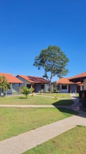 een gebouw met een boom in het midden van een park bij Pousada Chez bubônia in Novo Acordo