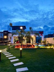a park with lights in the grass in front of a building at Soul Club - 1hr from HSR, Outdoor Cinema, Pool, Meditation Room, BBQ in Hosūr