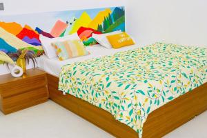 a bedroom with a bed with colorful sheets and pillows at Soul Club - 1hr from HSR, Outdoor Cinema, Pool, Meditation Room, BBQ in Hosūr +65 photos