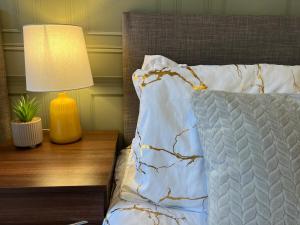 a bed with a pillow and a lamp on a table at Charming House - Walking distance to Town Centre - Sleeps 6 - Free Parking, Self-Check-In, Fast WiFi and Smart TV by Yoko Property in Rugby