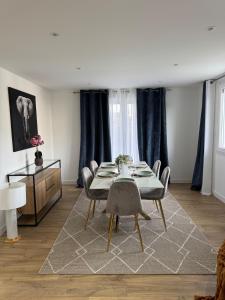 Un comedor con mesa y sillas en Longchamps 2 - Grand appartement 73m2 neuf spacieux, en Aix-les-Bains