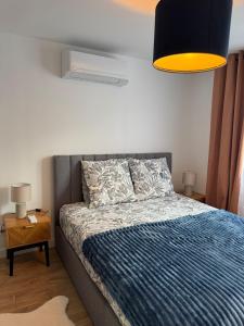 Un dormitorio con una cama con un edredón azul. en Longchamps 2 - Grand appartement 73m2 neuf spacieux, en Aix-les-Bains