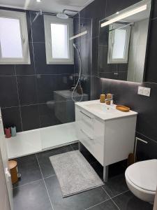 Un baño con lavabo, ducha e inodoro. en Longchamps 2 - Grand appartement 73m2 neuf spacieux, en Aix-les-Bains