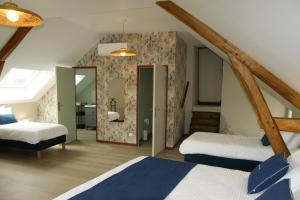 a attic bedroom with two beds and a mirror at Le Colombier - Chambre Mésange in Baule