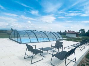 a group of chairs and tables on a patio at Szencsedi kulcsosház medencével in Sâncel