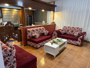 a living room with two couches and a coffee table at شقة مفروشة واسعة وهادئة in Umm Juraysāt