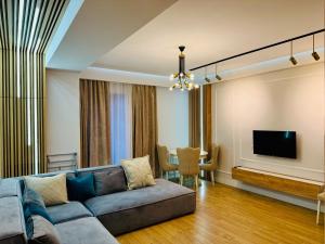 a living room with a couch and a television at Aparthotel Hilton Blox in Tbilisi City