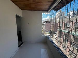 a large window in a building with a view of a city at Itapuã - 4 Minutos da Praia - Apartamento Espaçoso - 3 Quartos in Vila Velha