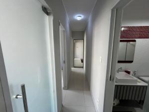 a white bathroom with a sink and a mirror at Itapuã - 4 Minutos da Praia - Apartamento Espaçoso - 3 Quartos in Vila Velha +42 photos