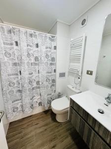 a bathroom with a toilet and a shower curtain at Maravilloso y central departamento in Chillán