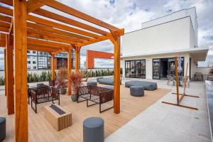 a patio with tables and chairs on top of a building at MUV proximo ao shopping in Curitiba