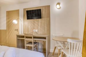 a bedroom with a desk and a table with a tv at Colivi Studio Cosy 50m Gare Annemasse in Annemasse