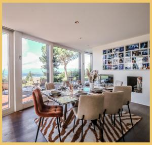 una sala da pranzo con tavolo e sedie di Villa vue Lac Léman et montagne Proche Genève a Cranves-Sales