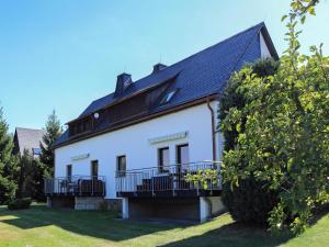 a white house with a black roof at Ferienwohnung Basteiblick in Pirna in Pirna