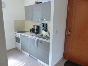a small kitchen with gray cabinets and a sink at Ferienwohnung Basteiblick in Pirna in Pirna