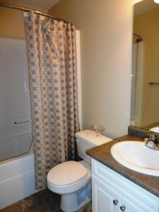 Un baño con inodoro, lavabo y ducha. en 1st Choice Bed and Breakfast, en Whitehorse