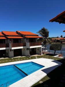 eine Villa mit einem Swimmingpool vor einem Haus in der Unterkunft Apto Completo na Ogiva - Cabo Frio in Peró