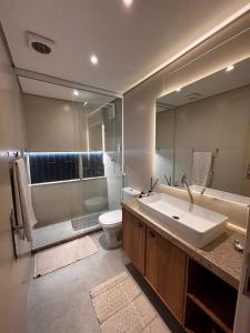 ein Badezimmer mit Waschbecken, Toilette und Spiegel in der Unterkunft Apto Completo na Ogiva - Cabo Frio in Peró