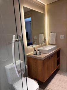 ein Badezimmer mit Waschbecken, Toilette und Spiegel in der Unterkunft Apto Completo na Ogiva - Cabo Frio in Peró + 42 Fotos