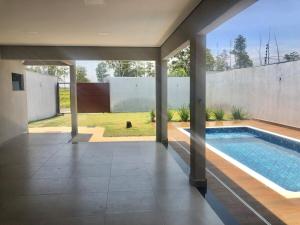 a swimming pool in the middle of a house at Moderna área com Wi-Fi e ar condicionado in Americana