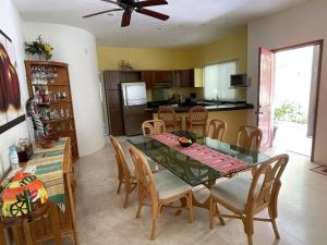 a kitchen and dining room with a glass table and chairs at Real Marina Blue 102B - Santa Cruz in Santa Cruz Huatulco