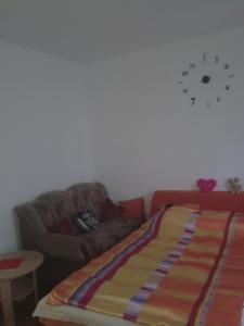 a living room with a couch and a clock on the wall at Горішній Пасічна Зелена Вулецька завод Іскра Біля лісу Новий Львів in Lviv +5 photos