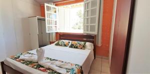 a small room with two beds and a window at Mares e Flores de Bombinhas in Bombinhas +23 photos