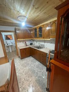 Una cocina con gabinetes de madera y un fregadero. en Nafo Rooms, en Gjirokastra