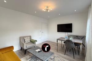 オールダーショットにある3 bedroom House Contractors and Groups sleeps 5のテーブルとテレビのあるリビングルーム