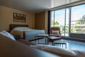 a bedroom with a bed and a couch and a table at L'apais'Han in Rochefort