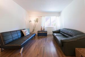 a living room with a leather couch and a table at One Bedroom Suite in perfect location Vancouvers Mount Pleasant in Vancouver