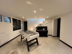 a room with a table and a piano at Suite Evasion - Jaccuzzi et petit déjeuner in Clermont