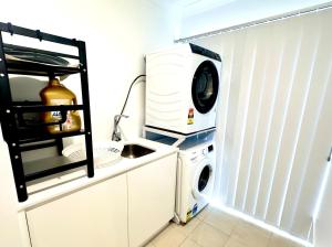 a washing machine and a washer in a kitchen at Fresh Built Spacious Retreat in Dubbo +6 photos