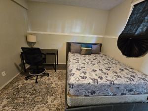 a bedroom with a bed and a desk and a chair at Basement Appartment in Edmonton