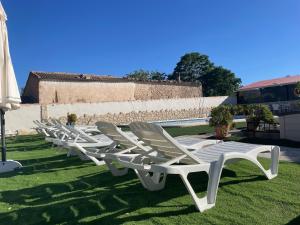 eine Reihe weißer Liegestühle auf dem Gras in der Unterkunft CORTIJO EL PRADO l in Castril
