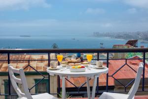 a table with food and drinks on a balcony at Hotel Casa Somerscales in Valparaíso