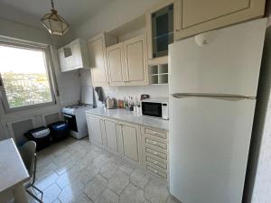 a kitchen with white cabinets and a white refrigerator at Affittacamere LICEN in Trieste