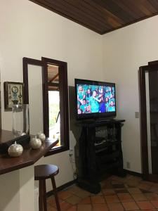 un soggiorno con TV e specchio di Casa Cabral - Pipa Natureza a Pipa