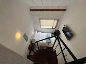 a small bedroom with a bed and a staircase at Hotel Villa Macondo in Villa de Leyva