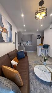 un soggiorno con un divano marrone e una cucina di Stylish 1-Bedroom with Stunning City View atNova with PS-5 a Accra