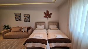 a bedroom with two beds and a couch at Douceur Neroli à Ain zaghouen Nord in Sidi Daoud