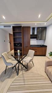 a living room with a glass table and two chairs at Douceur Neroli à Ain zaghouen Nord in Sidi Daoud