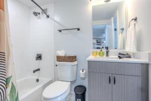 Un baño con inodoro, lavabo y bañera. en Stylish Apartment 5 min to DC with free Gym and Parking, en Arlington 23 fotos más