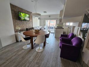 a living room with a wooden table and purple chairs at Dto nueva cordoba in Barraquero
