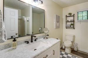 a bathroom with a sink and a toilet and a mirror at Hiwassee River Gem with Huge Decks Great for Groups in Mountain Scene +35 photos