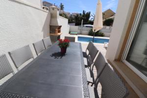 a table with chairs and a potted plant on a balcony at Villa Llevant in Miami Platja