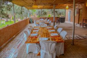 a long table with white chairs and plates on it at auberge Brava Tifnit 